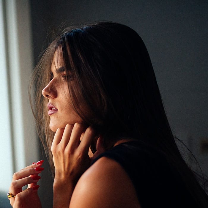 A woman looking out the window who has dental anxiety for her upcoming appointment.