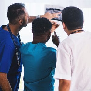 Men in a dental career reviewing dental x-rays.