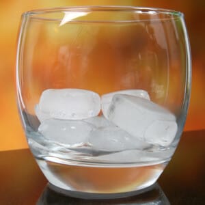 several ice cubes sitting in an empty drinking glass
