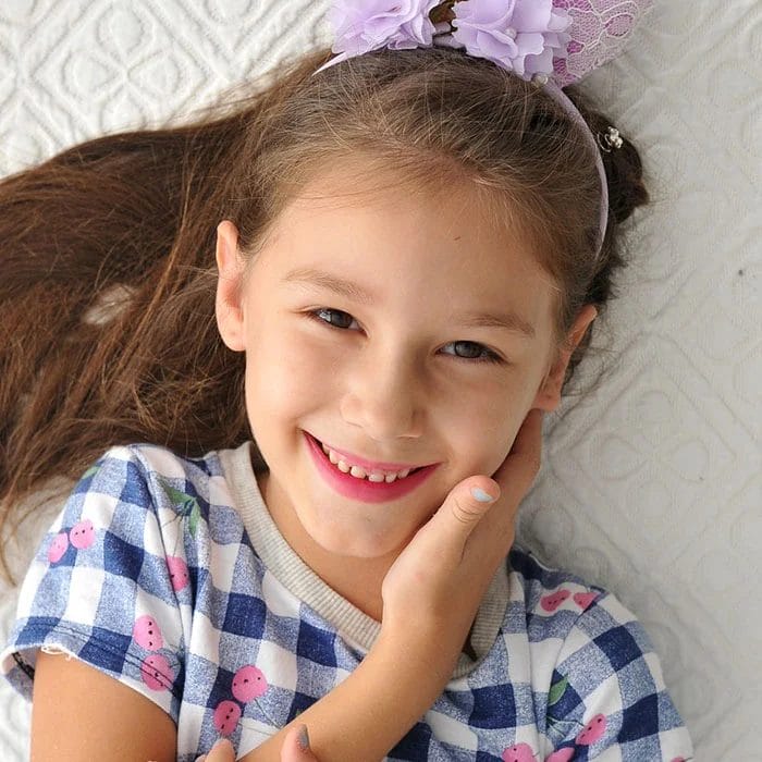 Smiling little girl holding her cheek
