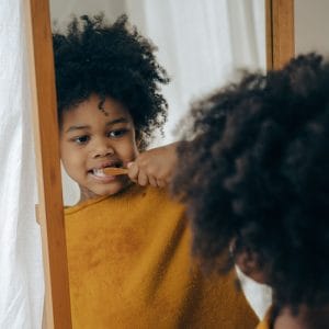 child practicing good dental habits by brushing their teeth.