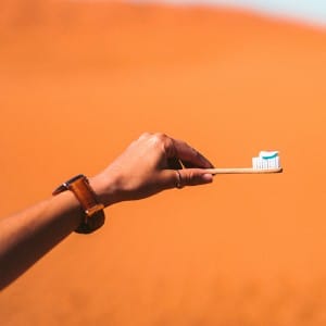 a hand holding a toothbrush with toothpaste on it.